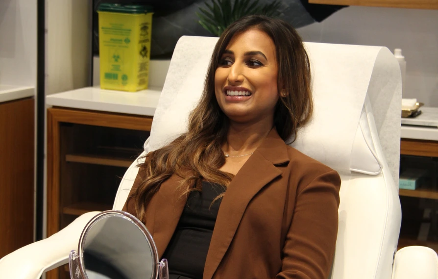 injectables patient smiling holding a mirror