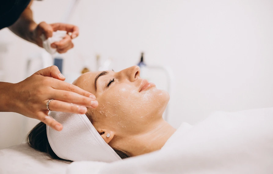 smiling woman during exfoliation treatment facial