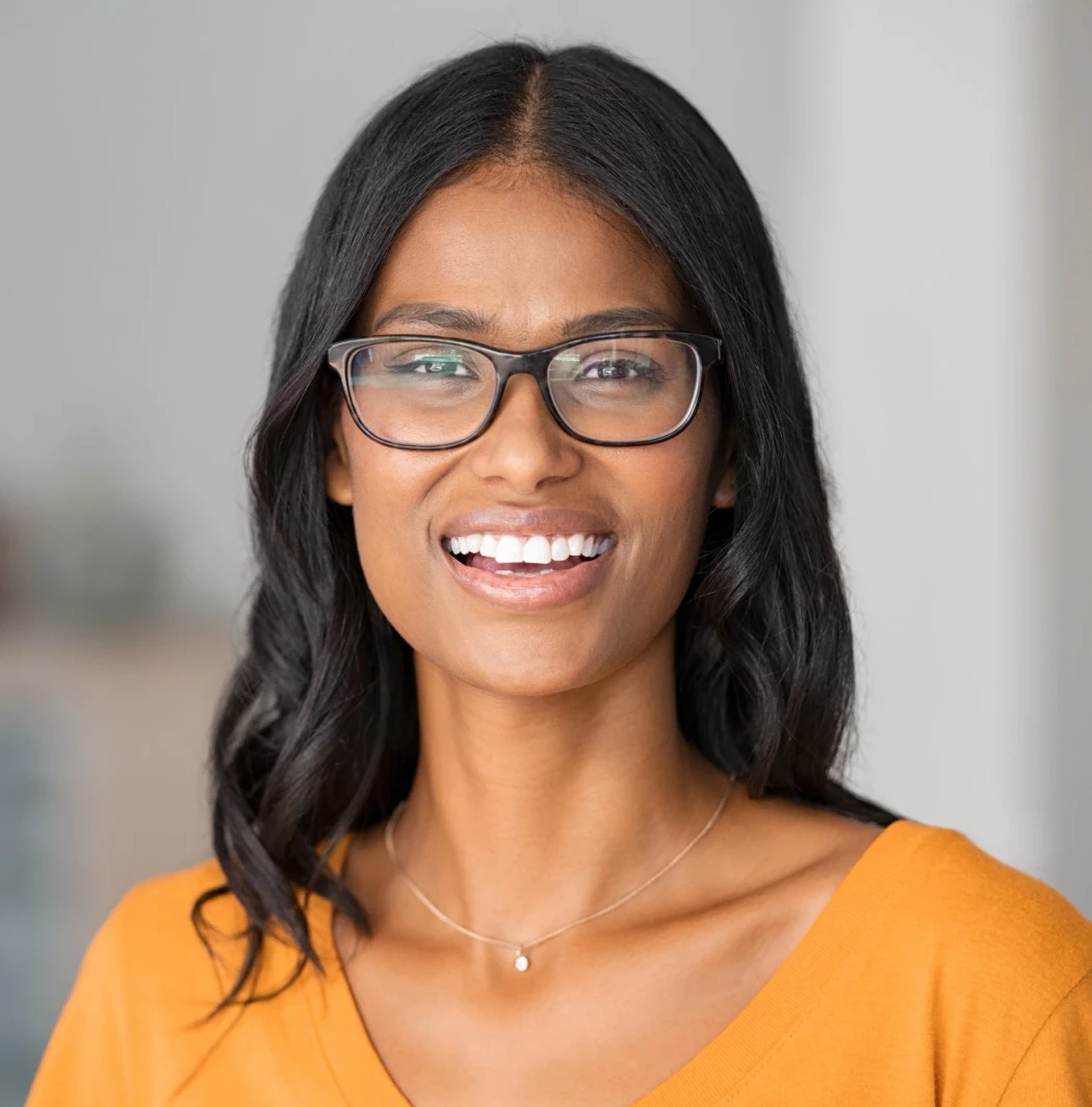 smiling woman with black hair and glasses