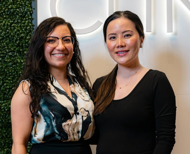 nurse injectors smiling infront of skin clinic sign