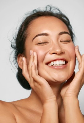 smiling asian woman touching her face