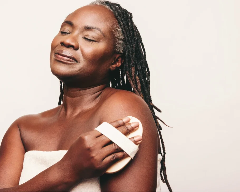 black woman exfoliating dry skin on her arm