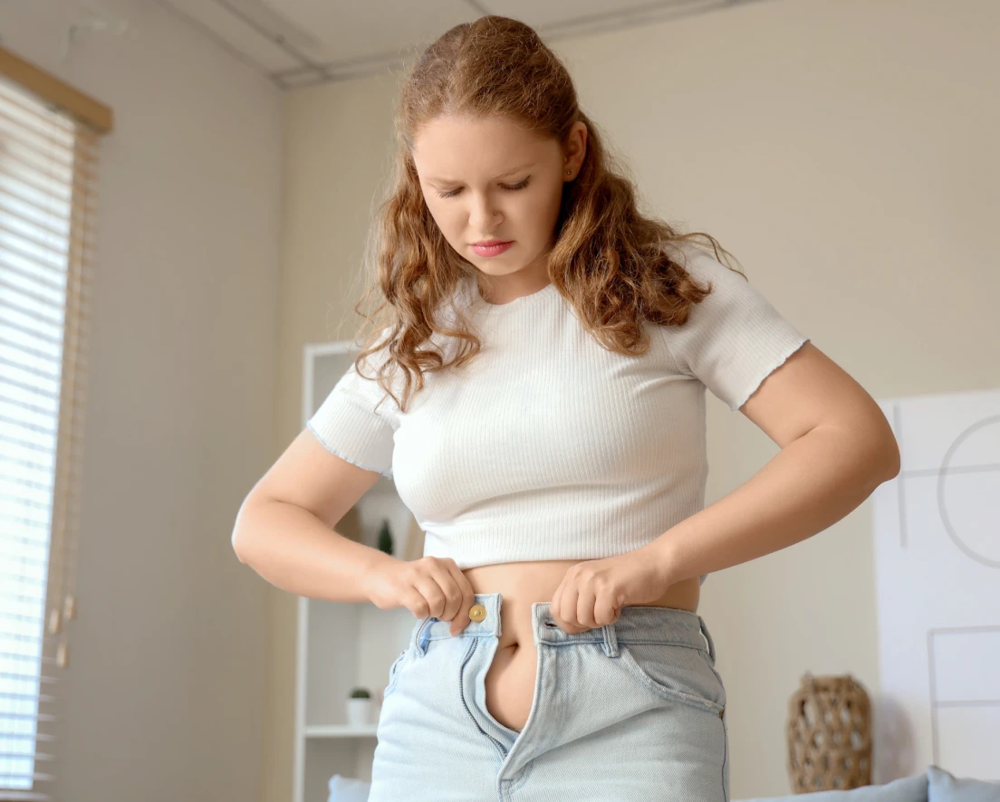 woman fitting into jeans too small