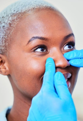 black woman smiling getting injectable rhinoplasty consultation